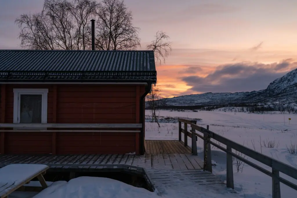 red cabin in snowy Swedish Lapland at sunset